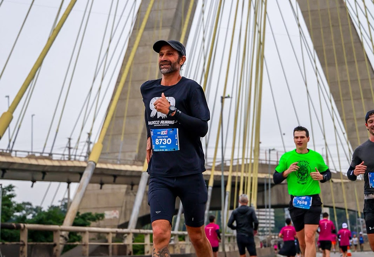 Atleta da Pacheco Running correndo prova em grande metrópole com regata oficial e número de peito